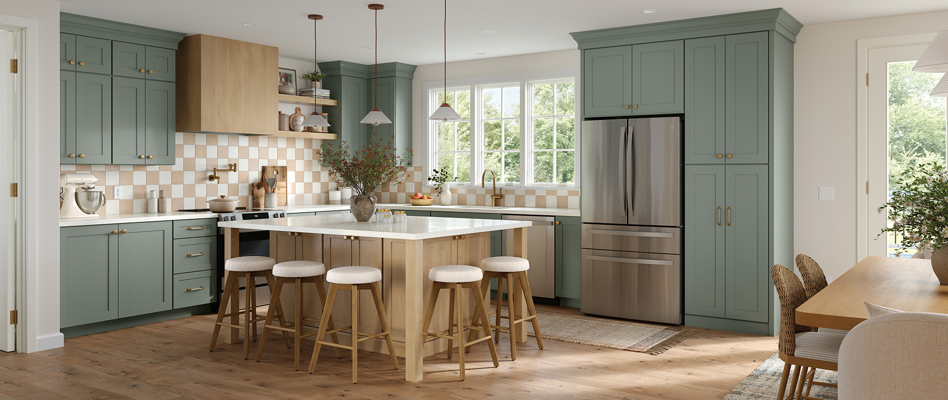 Modern kitchen featuring green shaker-style cabinets, light wood island with seating, stainless steel appliances, and checkered backsplash.